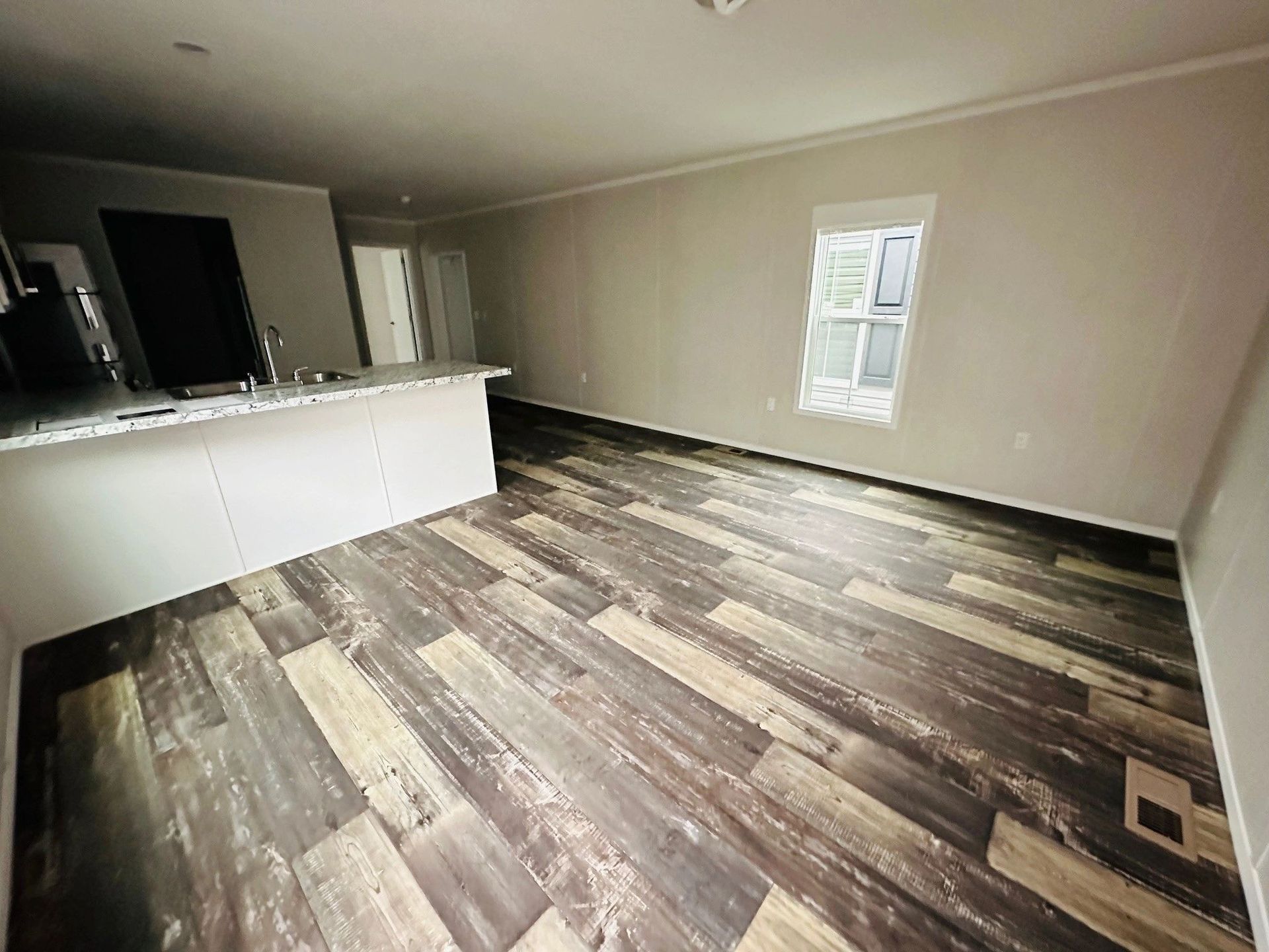 A living room with hardwood floors and a window.