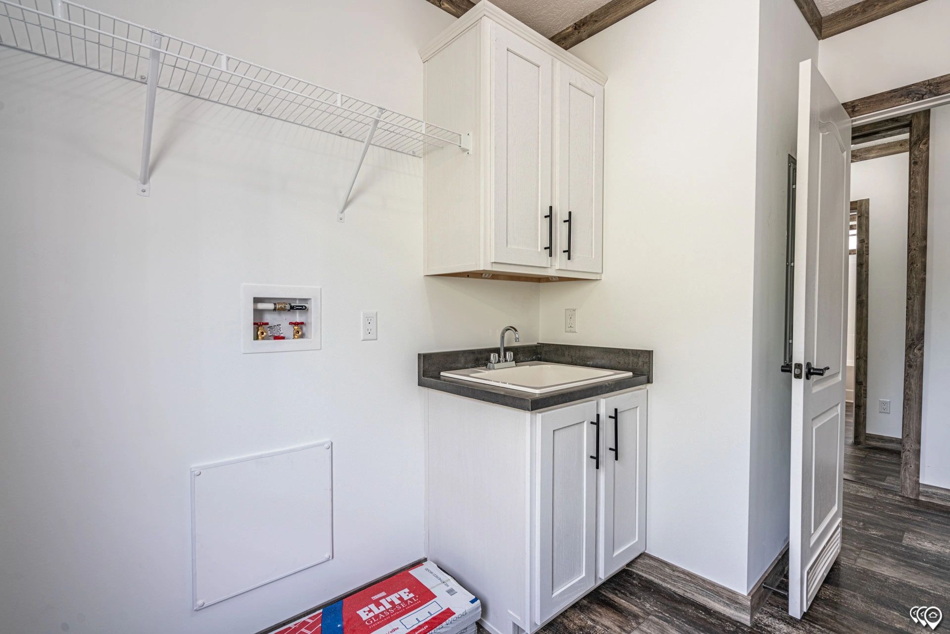 A laundry room with a sink and cabinets in a mobile home.