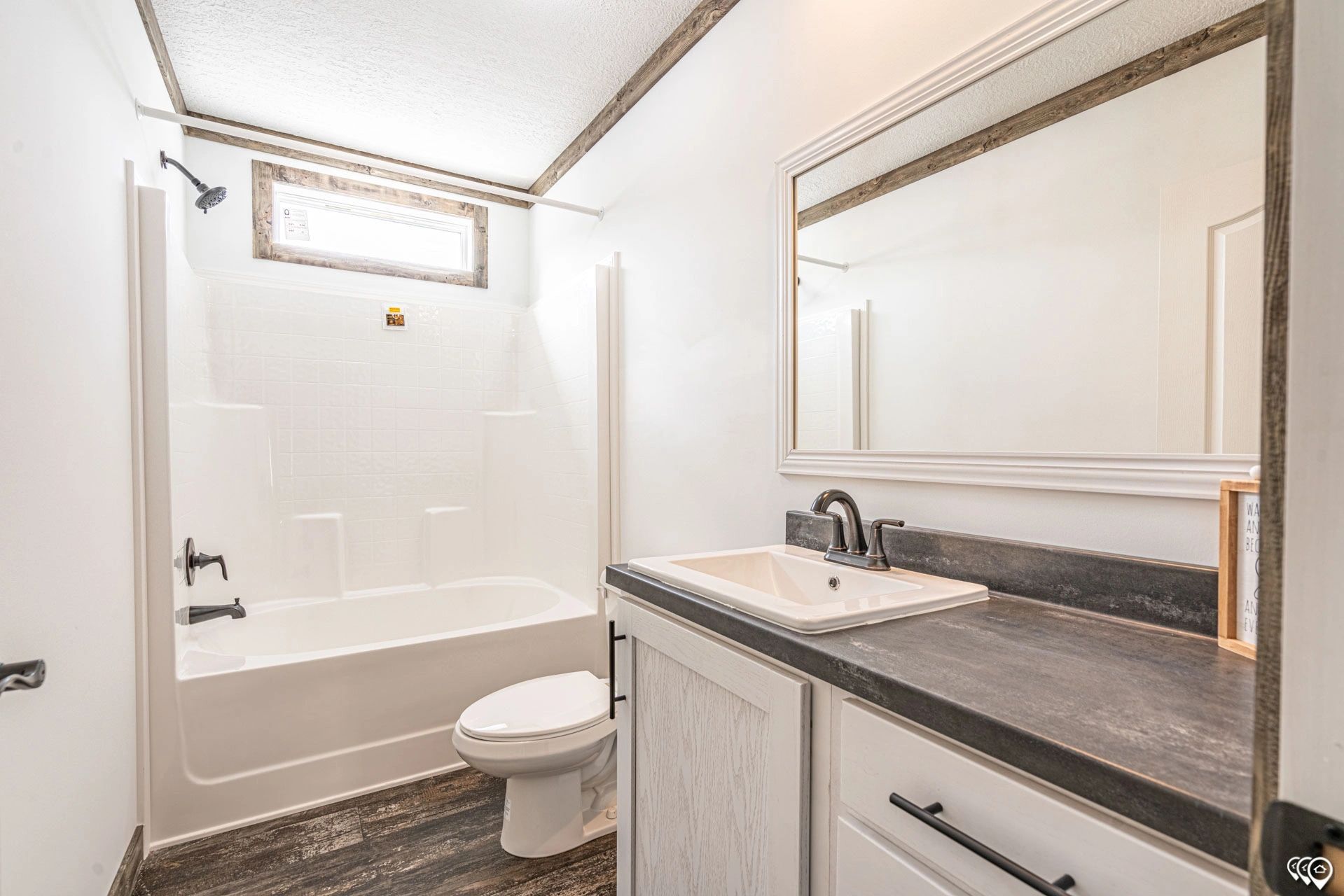 A bathroom with a sink , toilet , tub and mirror.