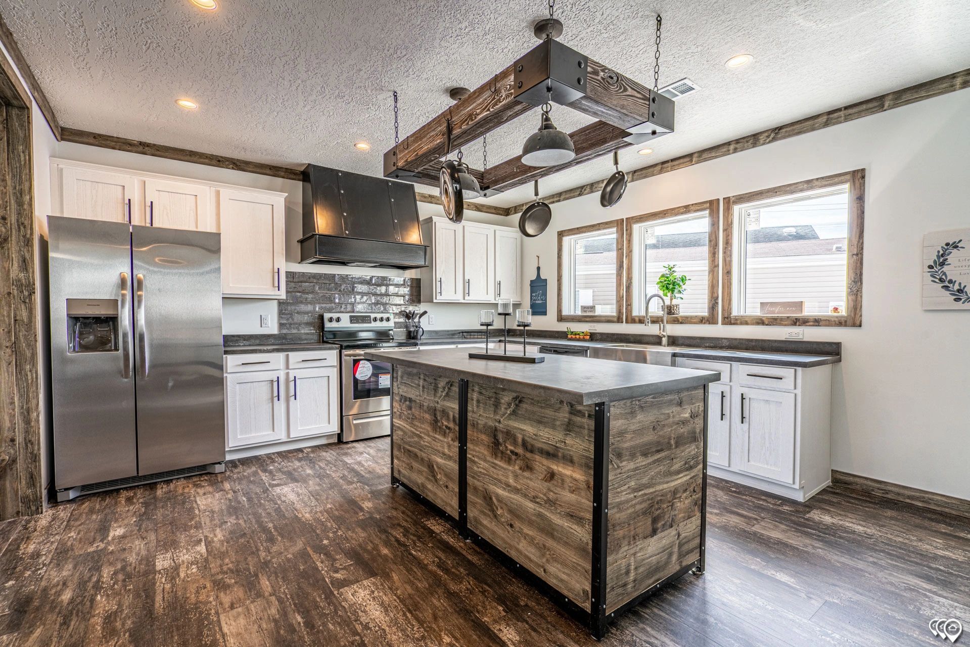 A kitchen with stainless steel appliances and a large wooden island.