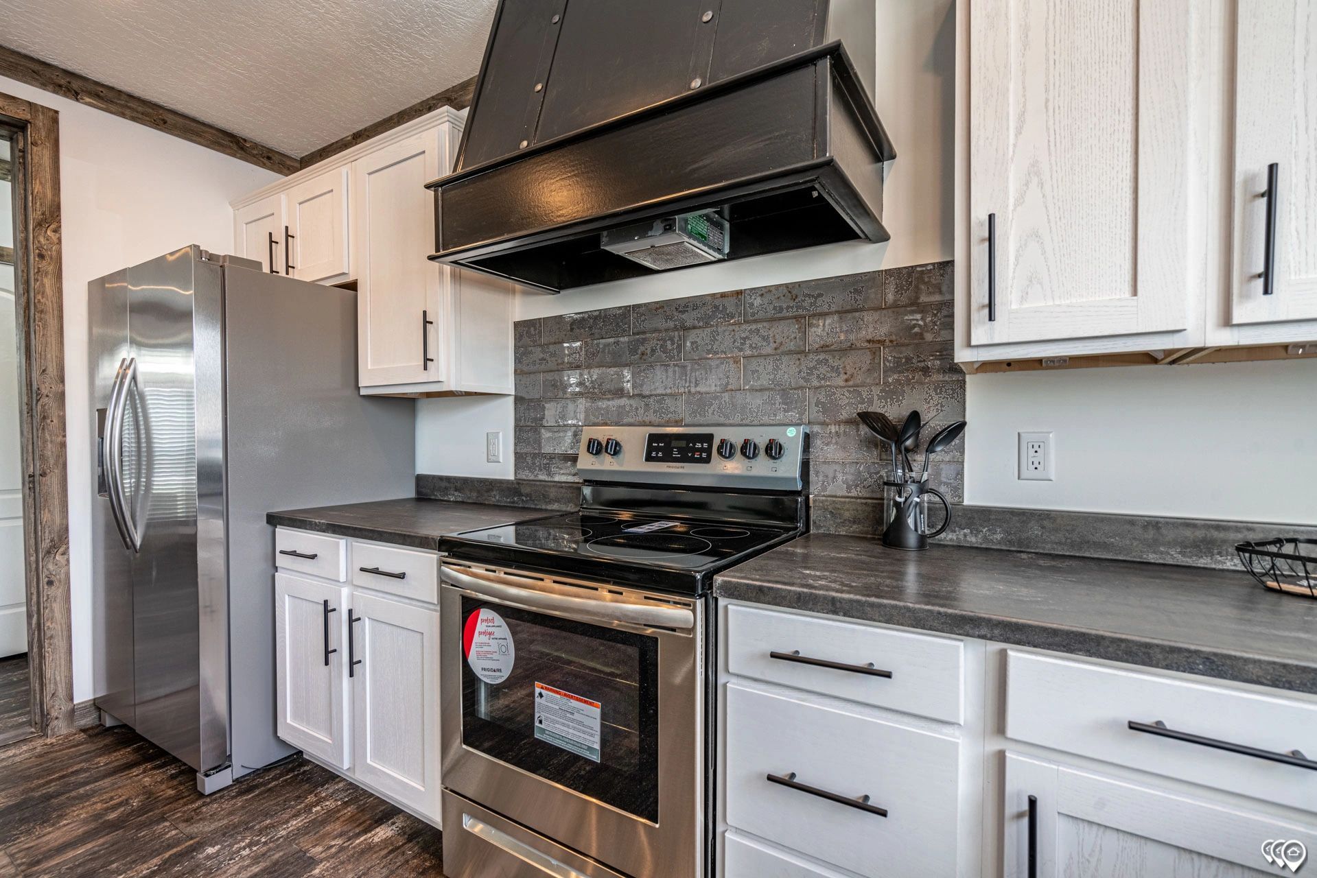A kitchen with stainless steel appliances and white cabinets.