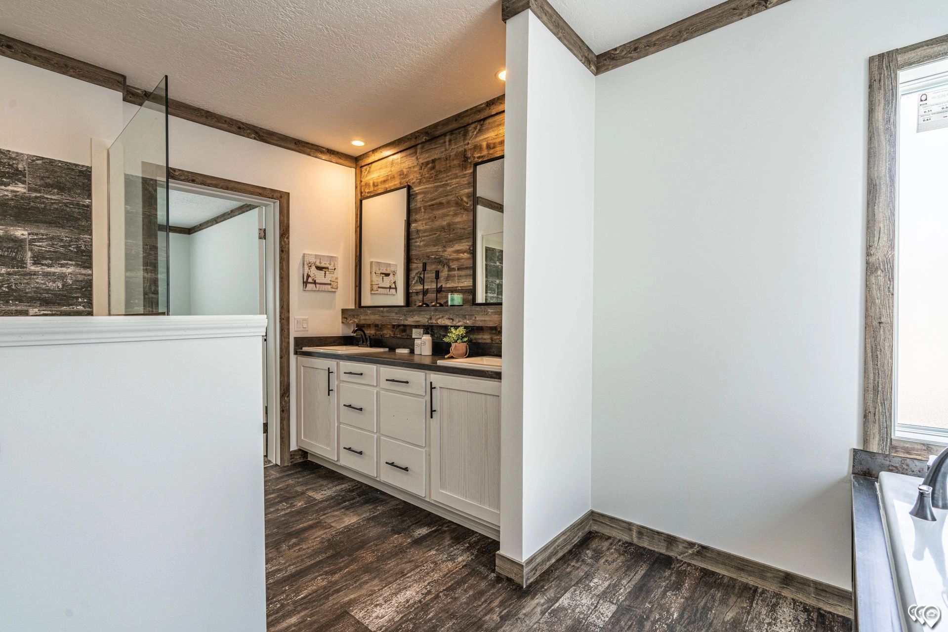 A bathroom with two sinks and a walk in shower.