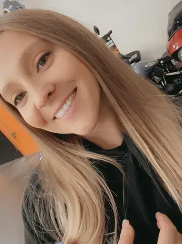 A woman with long blonde hair is smiling for the camera.