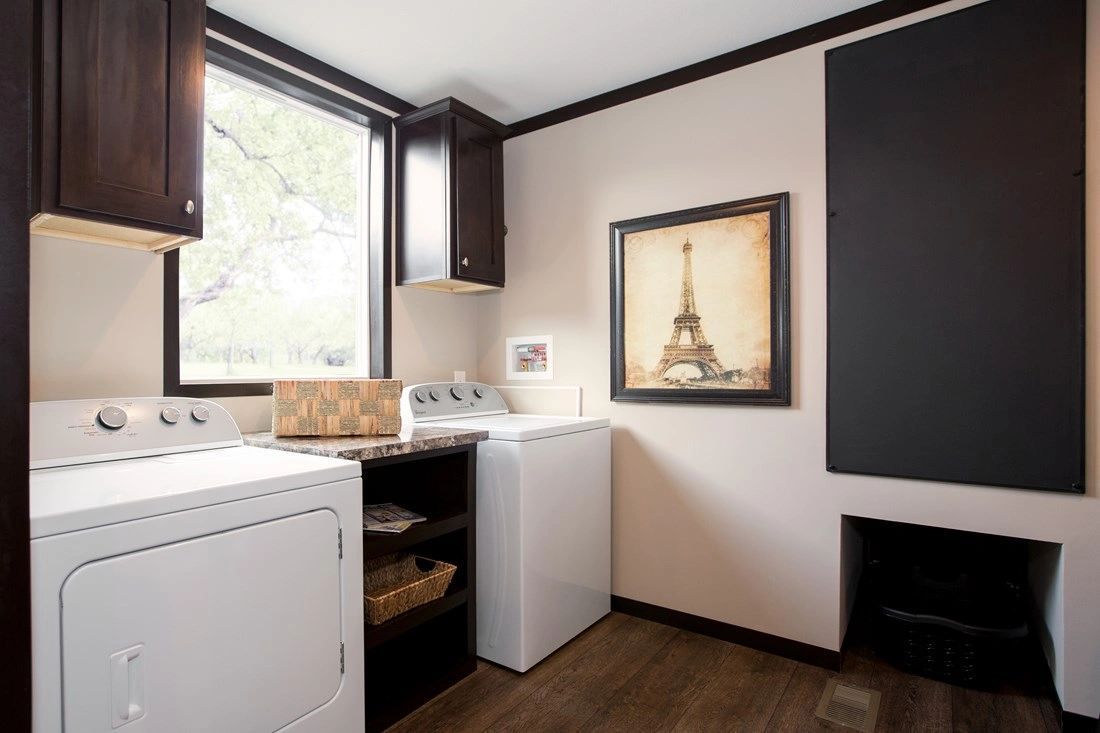 A laundry room with a washer and dryer and a picture of the eiffel tower on the wall.