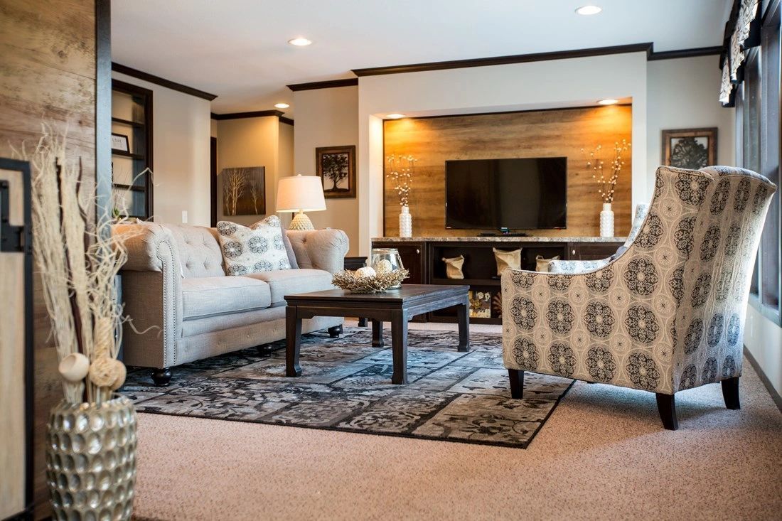 A living room with a couch , chairs , coffee table and television.