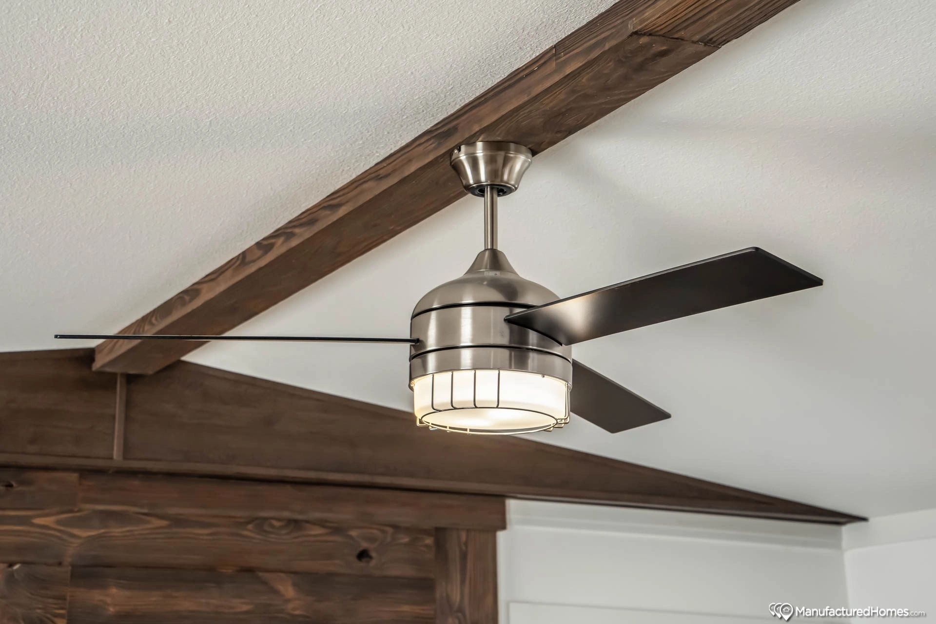 A ceiling fan with a light attached to it is hanging from the ceiling of a room.
