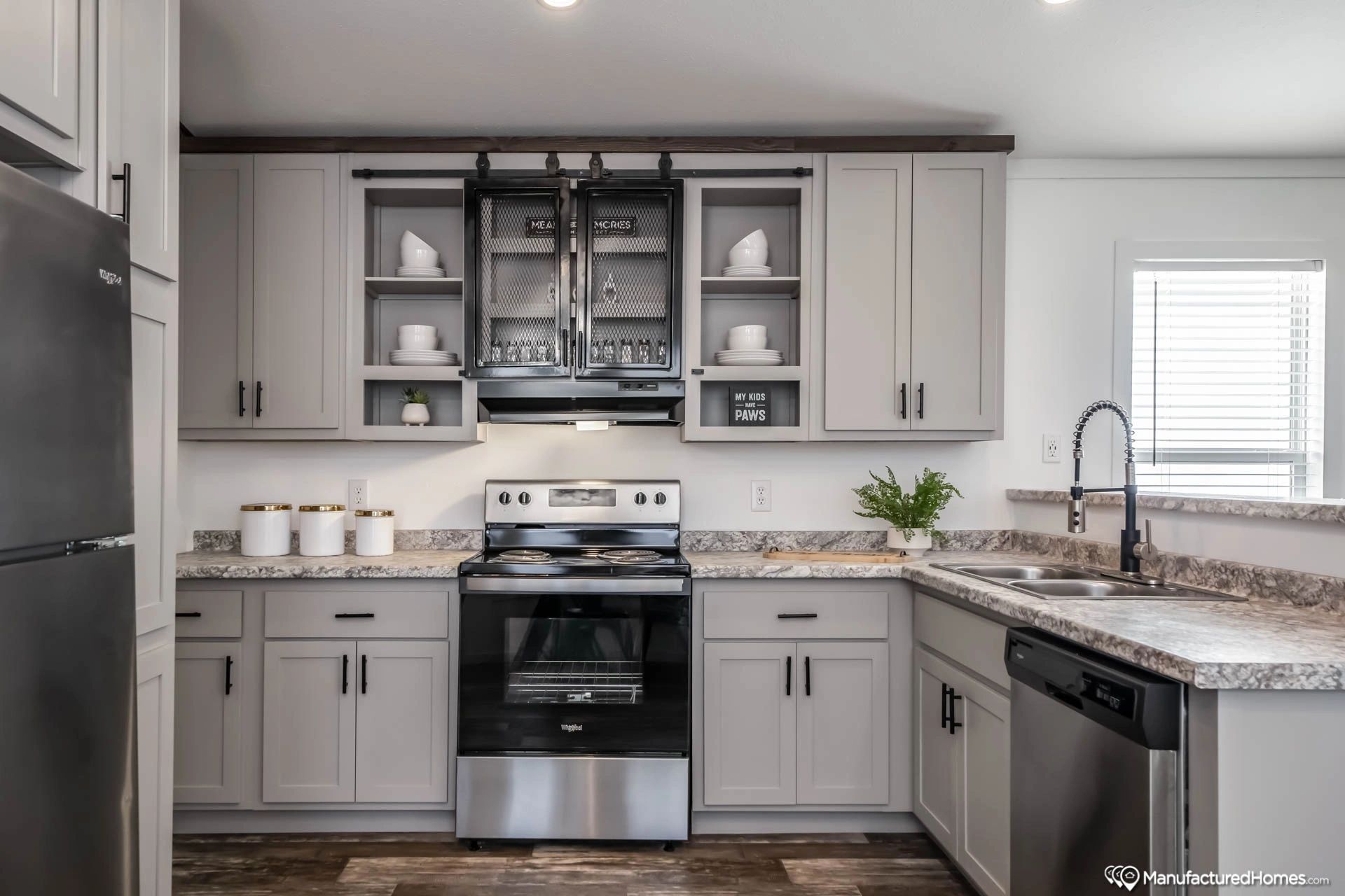 A kitchen with stainless steel appliances and gray cabinets