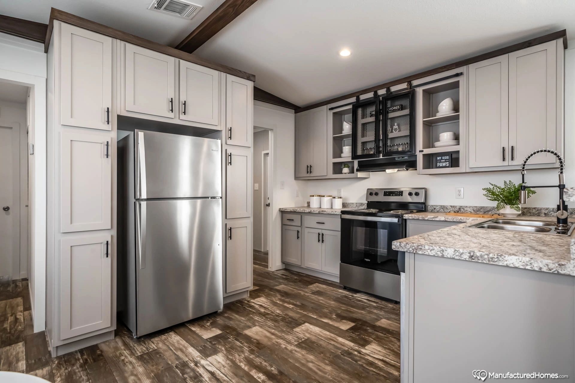 A kitchen with stainless steel appliances and white cabinets.