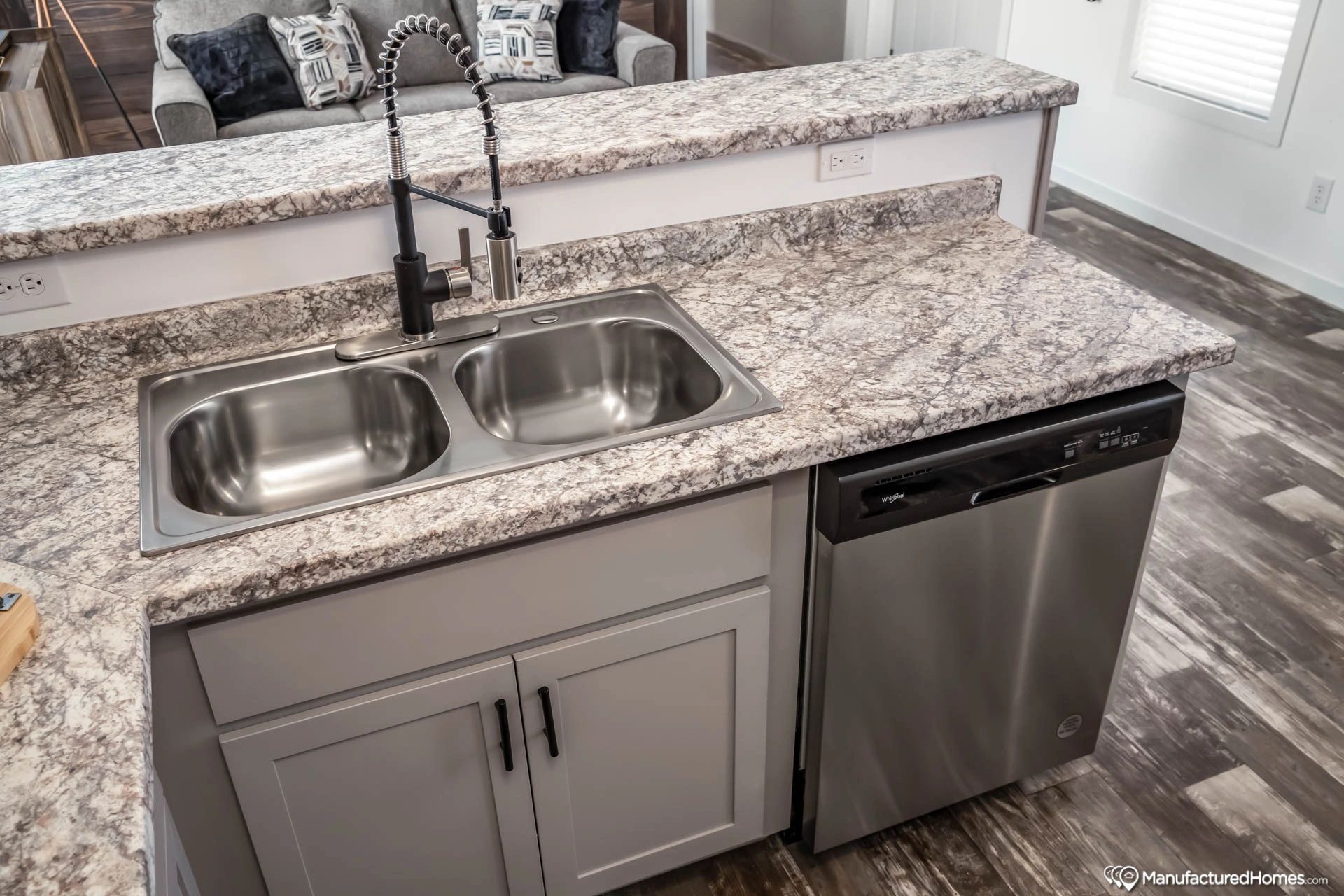 A kitchen with a sink , dishwasher , and granite counter tops.