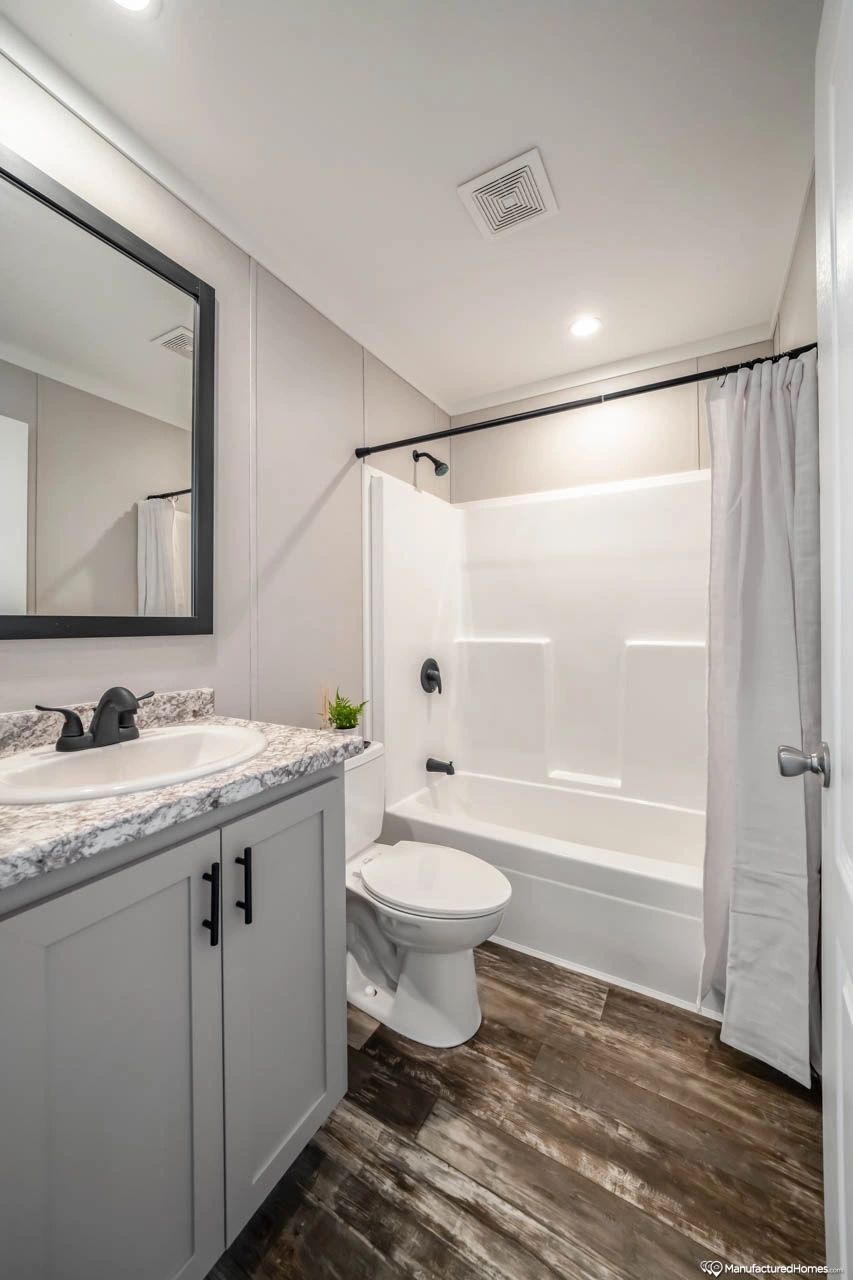 A bathroom with a toilet , sink , and bathtub.