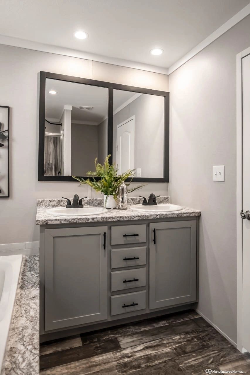 A bathroom with two sinks and a large mirror.
