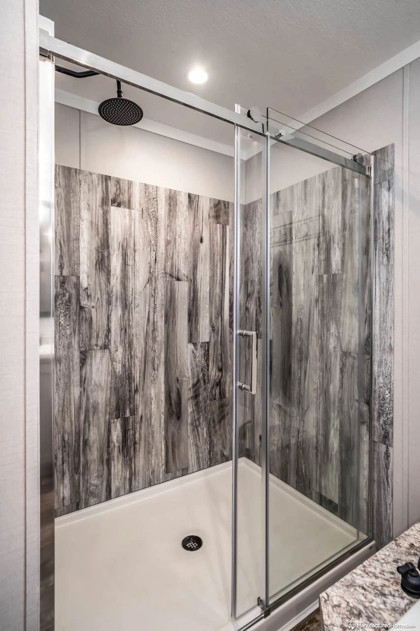 A bathroom with a sliding glass shower door and a shower head.