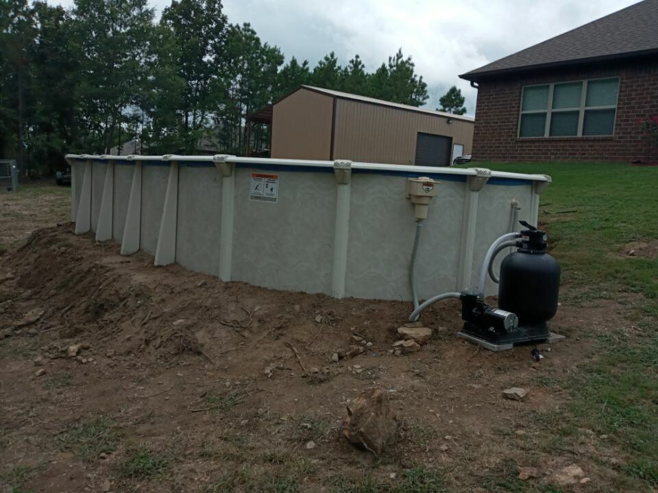A swimming pool is being built in the backyard of a house