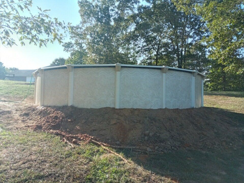 A swimming pool is sitting on top of a pile of dirt