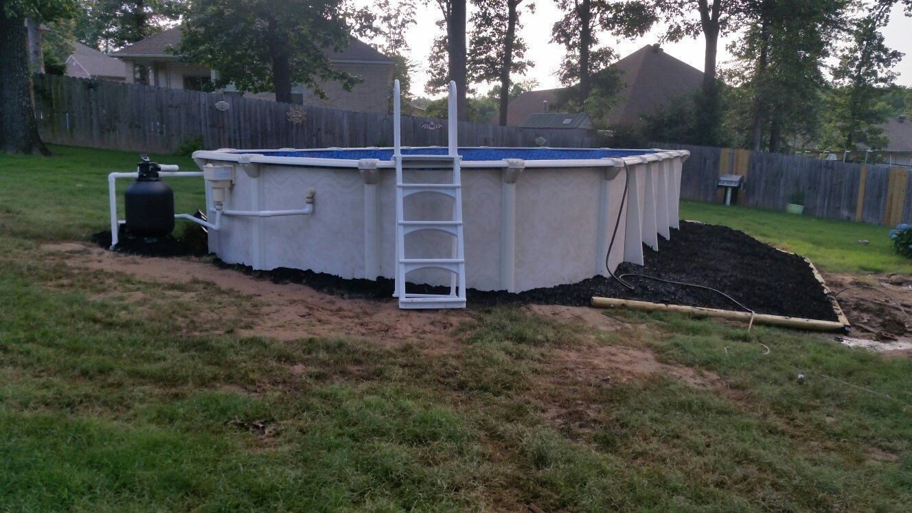 A white swimming pool with a ladder attached to it in a backyard.