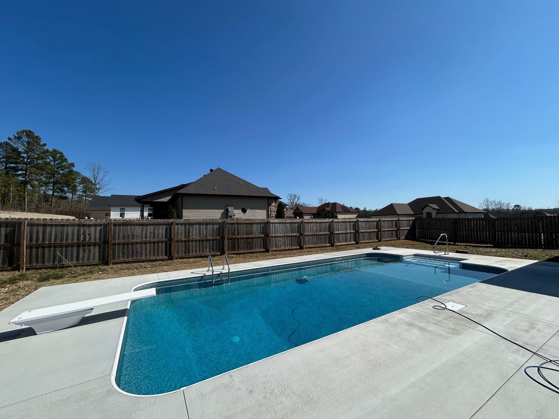 A large swimming pool with a wooden fence around it