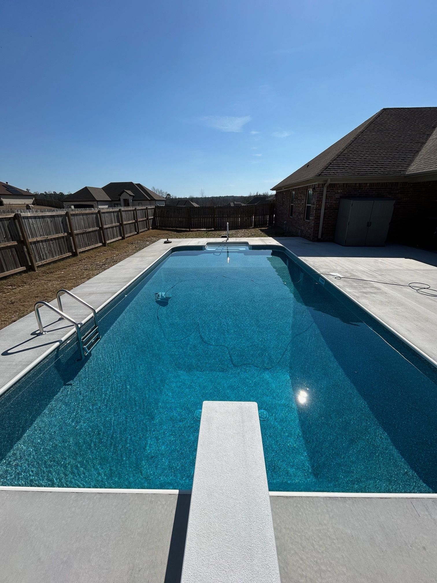 A large swimming pool with a diving board in the middle