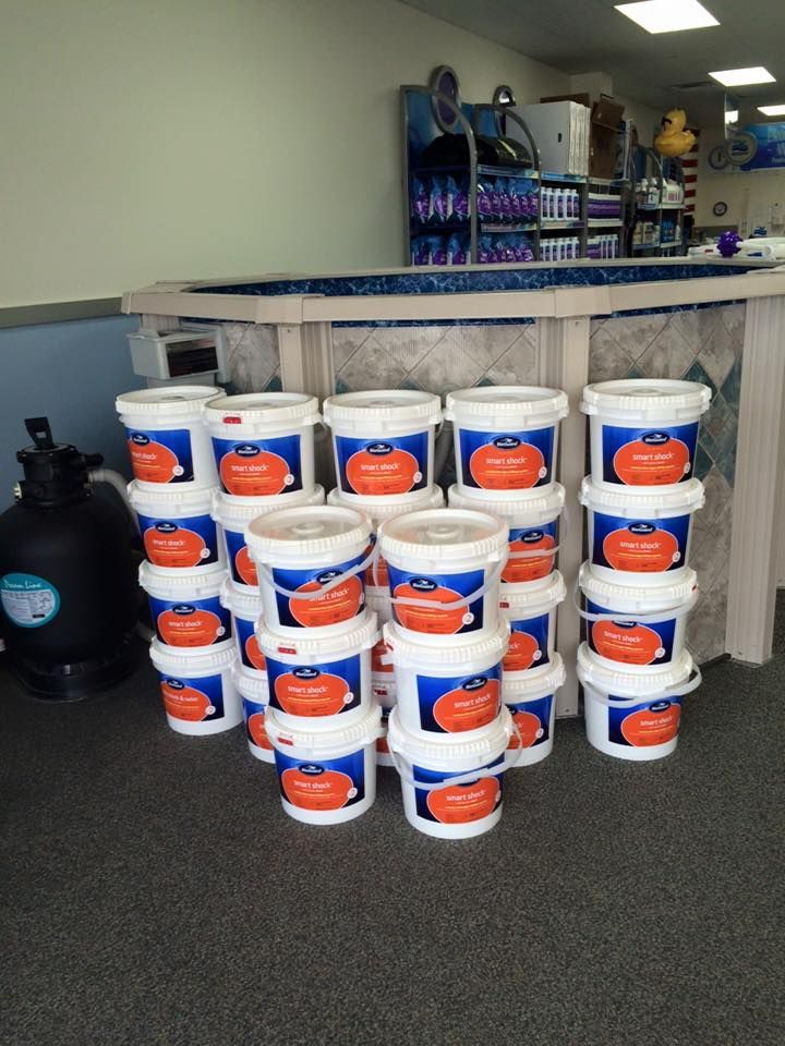 A bunch of buckets with pumpkins on them are stacked on top of each other