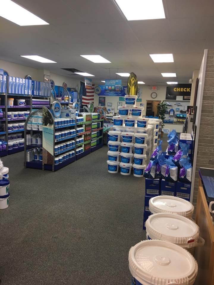 A large room filled with lots of buckets of pool supplies.