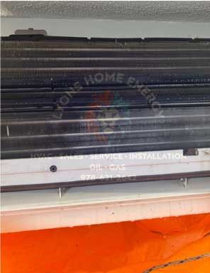 Close-up of a heating or AC unit's fins with Lyons Home Energy's logo and contact info.