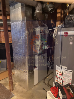 Furnace and water heater in a basement. Metal ducts and insulation visible.