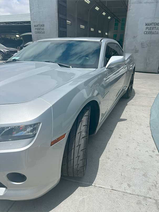 Silver sports car parked outside a modern building entrance