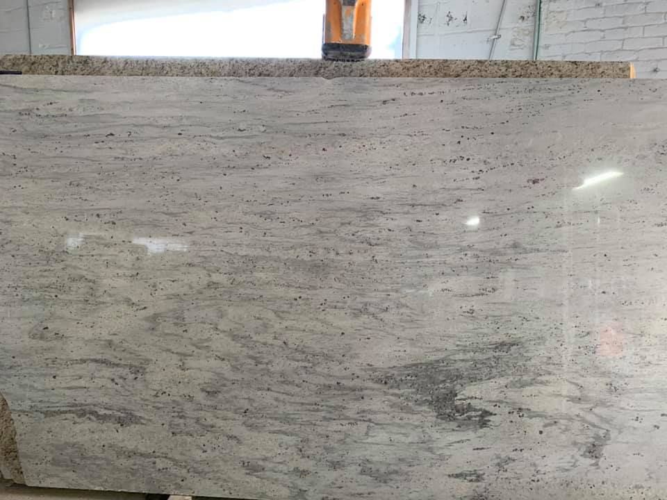 Light gray stone or marble countertop with subtle dark veining and reflective surface