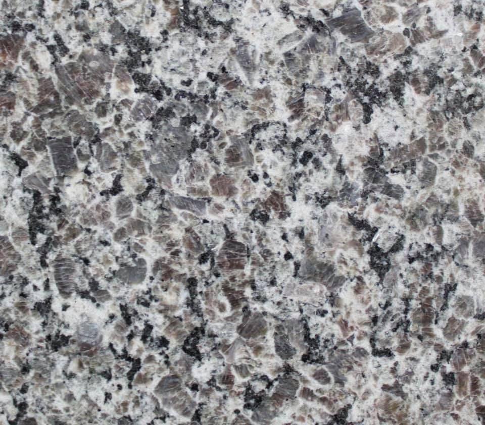 Close-up of a gray, white, and black speckled granite surface.