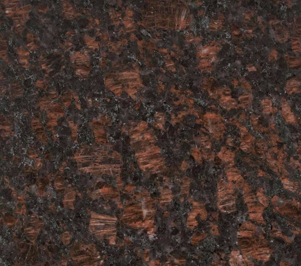 Dark speckled stone or granite surface with brown, black, and reddish tones