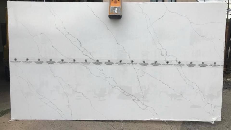 Large white marble-look slab with a horizontal row of small metal hooks across the middle