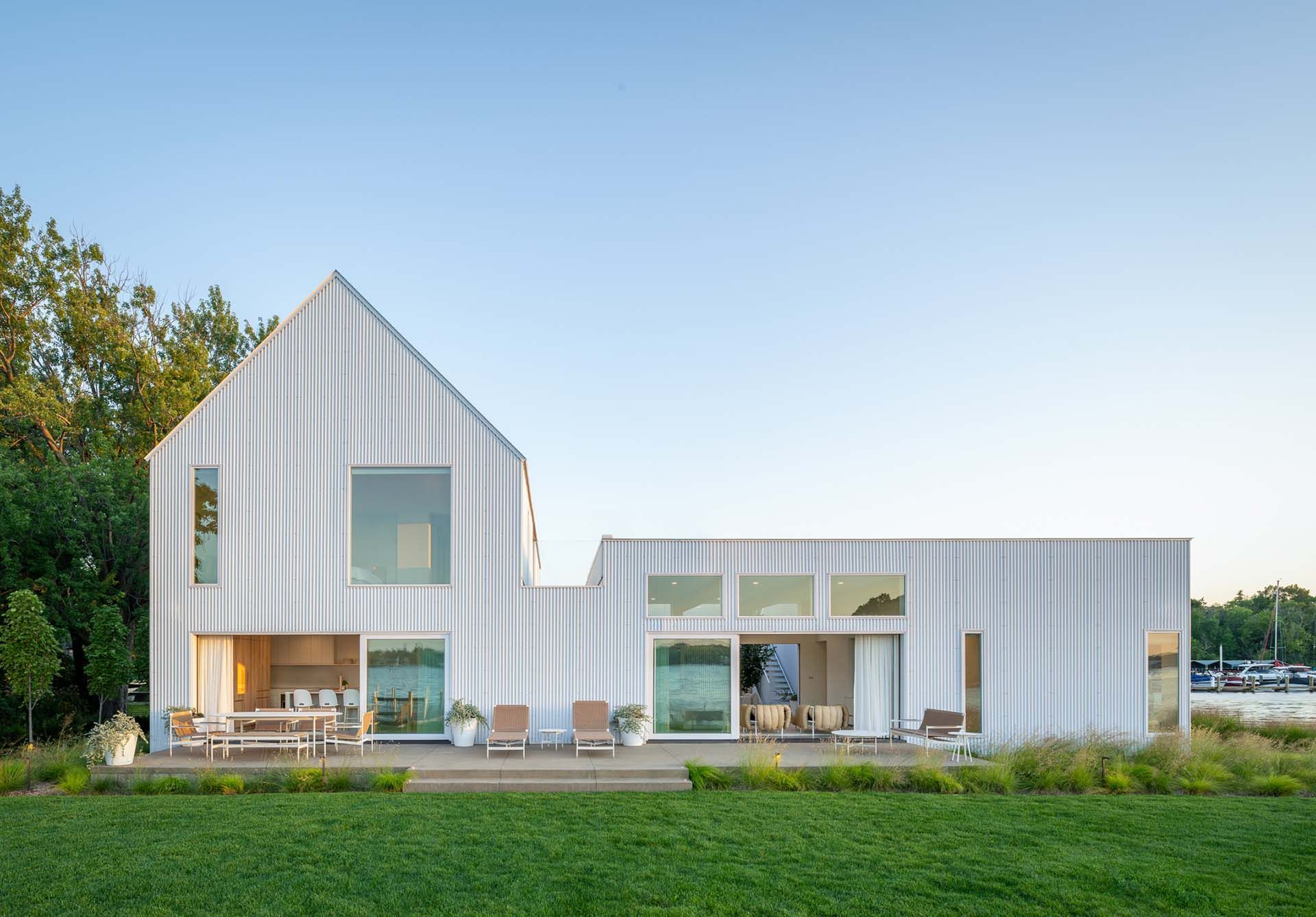 A white house is sitting on top of a lush green field.