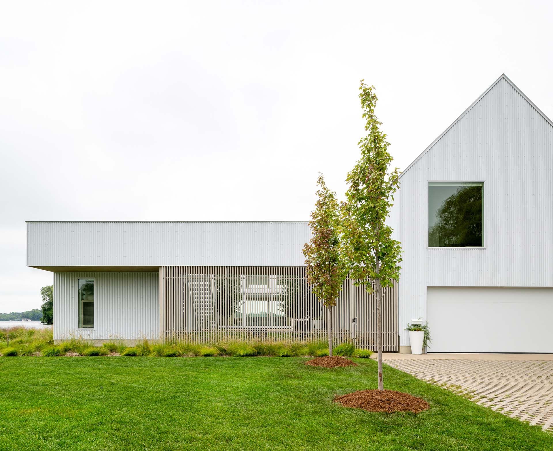 A modern style white house with a green lawn and new landscaping.