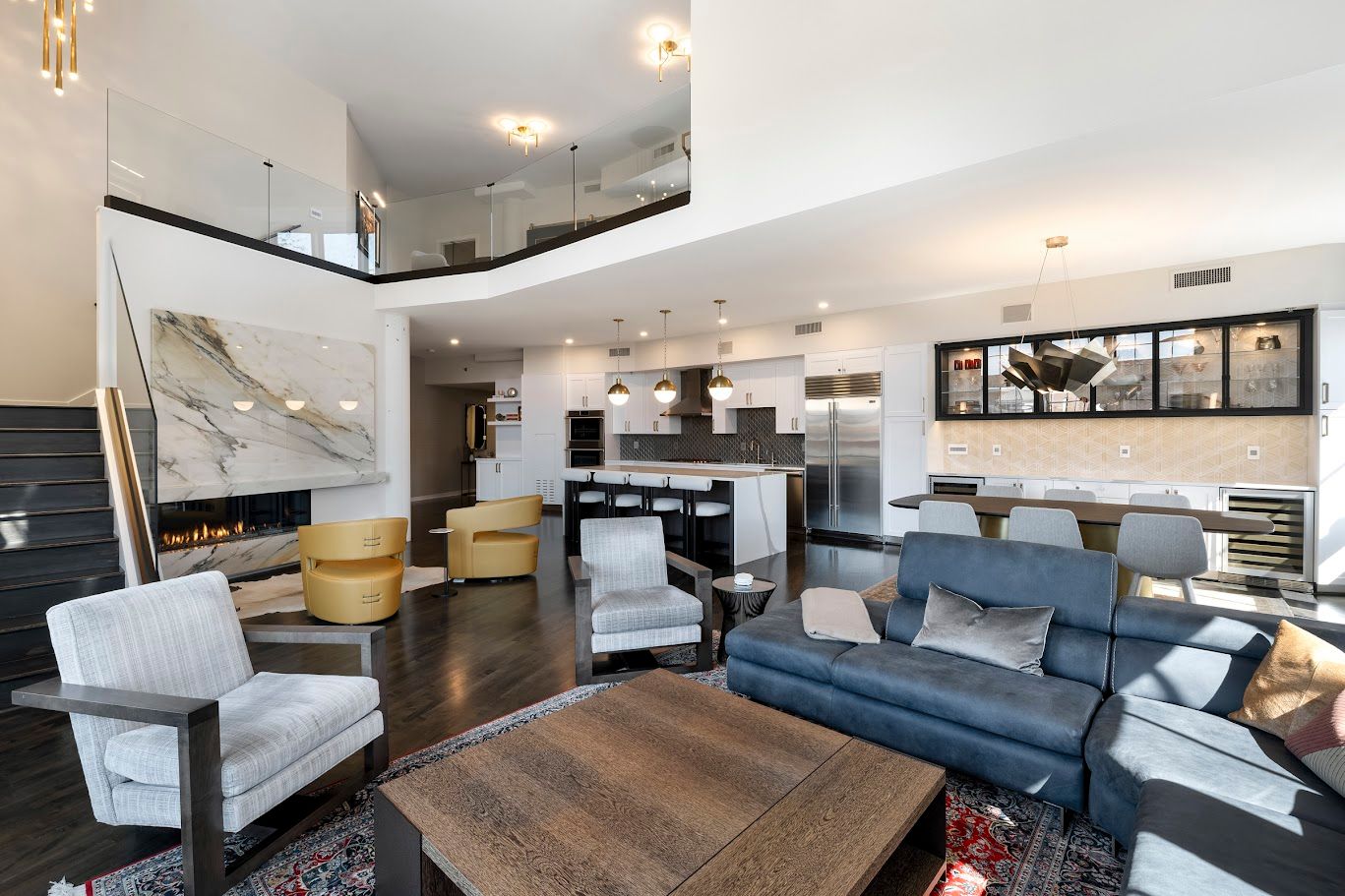 Spacious modern home interior with open kitchen, living room, and a loft area above.