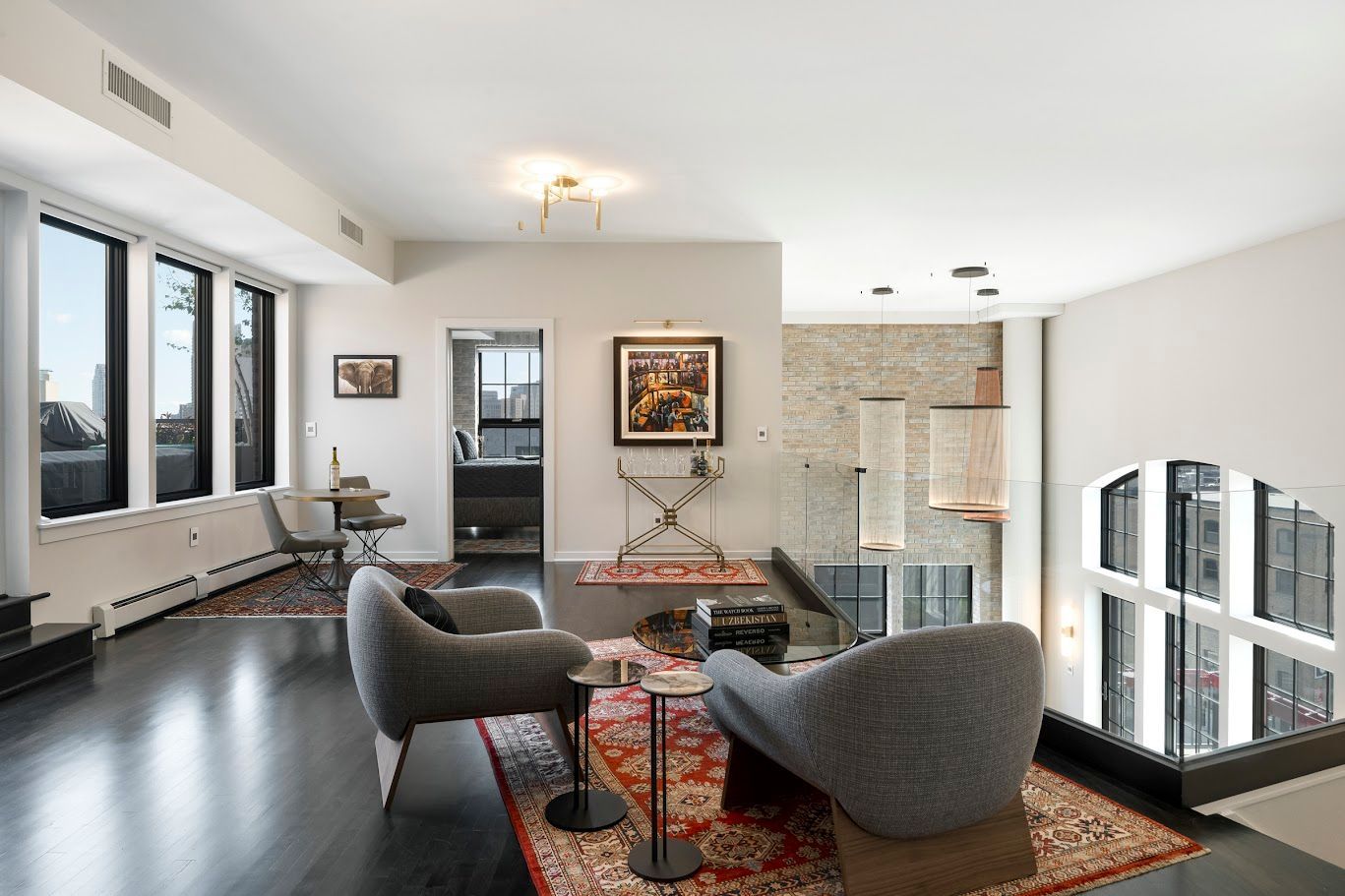 Modern living room with dark floors, large windows, and contemporary furniture.