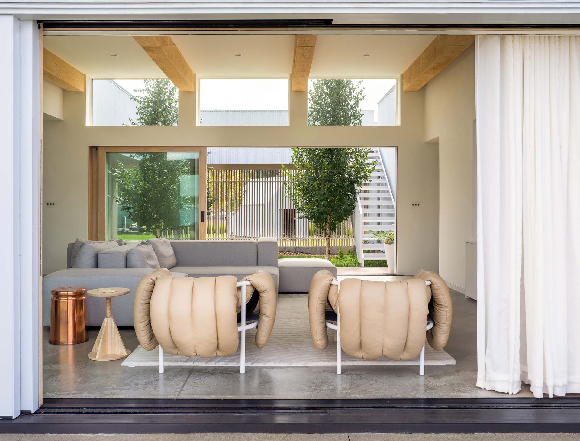 A living room with a couch , chairs , and sliding glass doors.