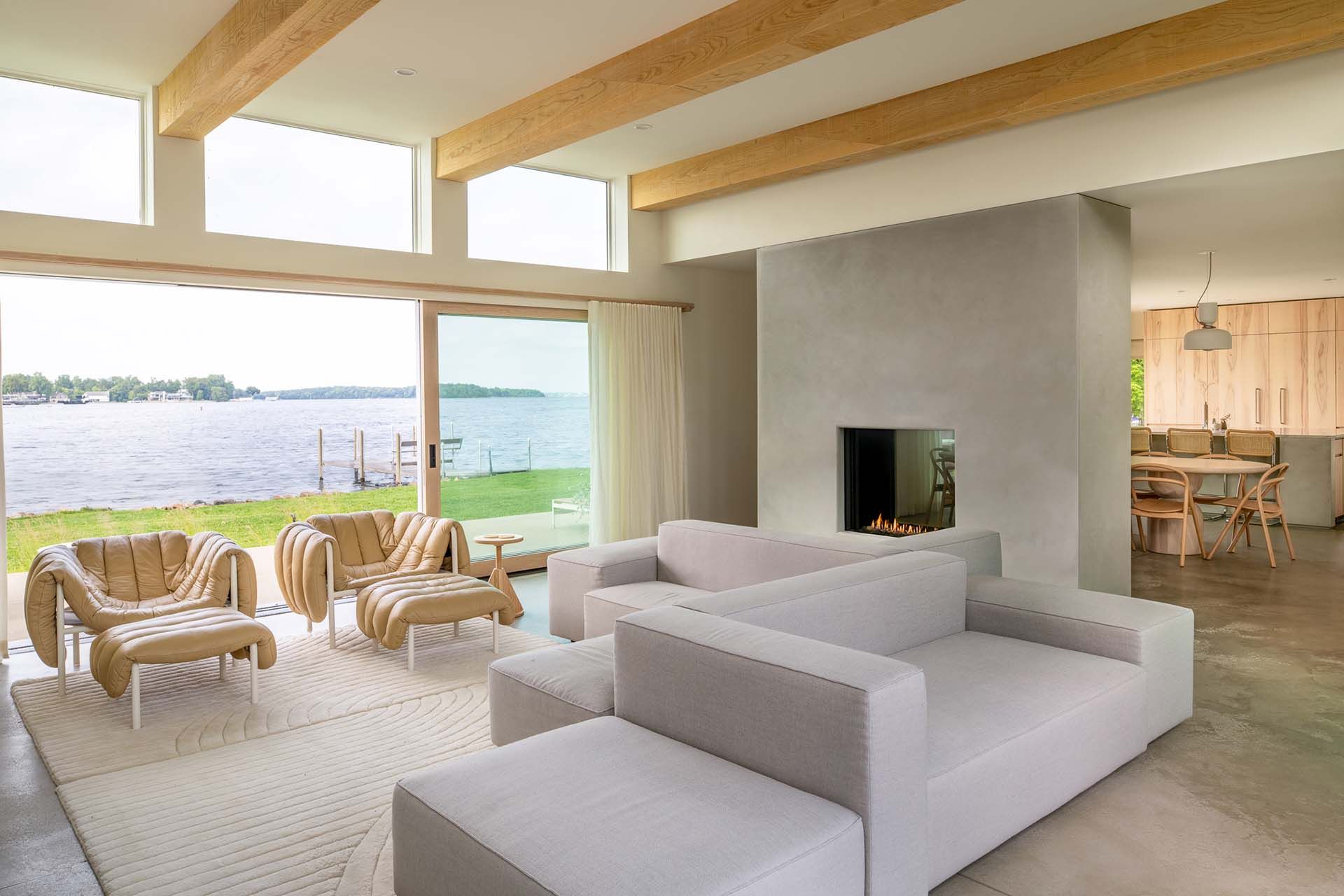 A living room filled with furniture and a fireplace with a view of the lake.