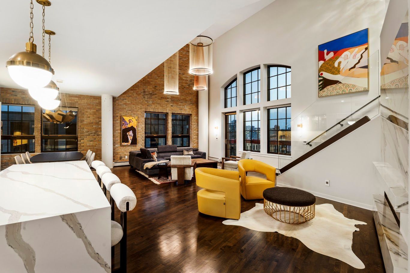 Loft living area with exposed brick, tall windows, and modern furnishings.