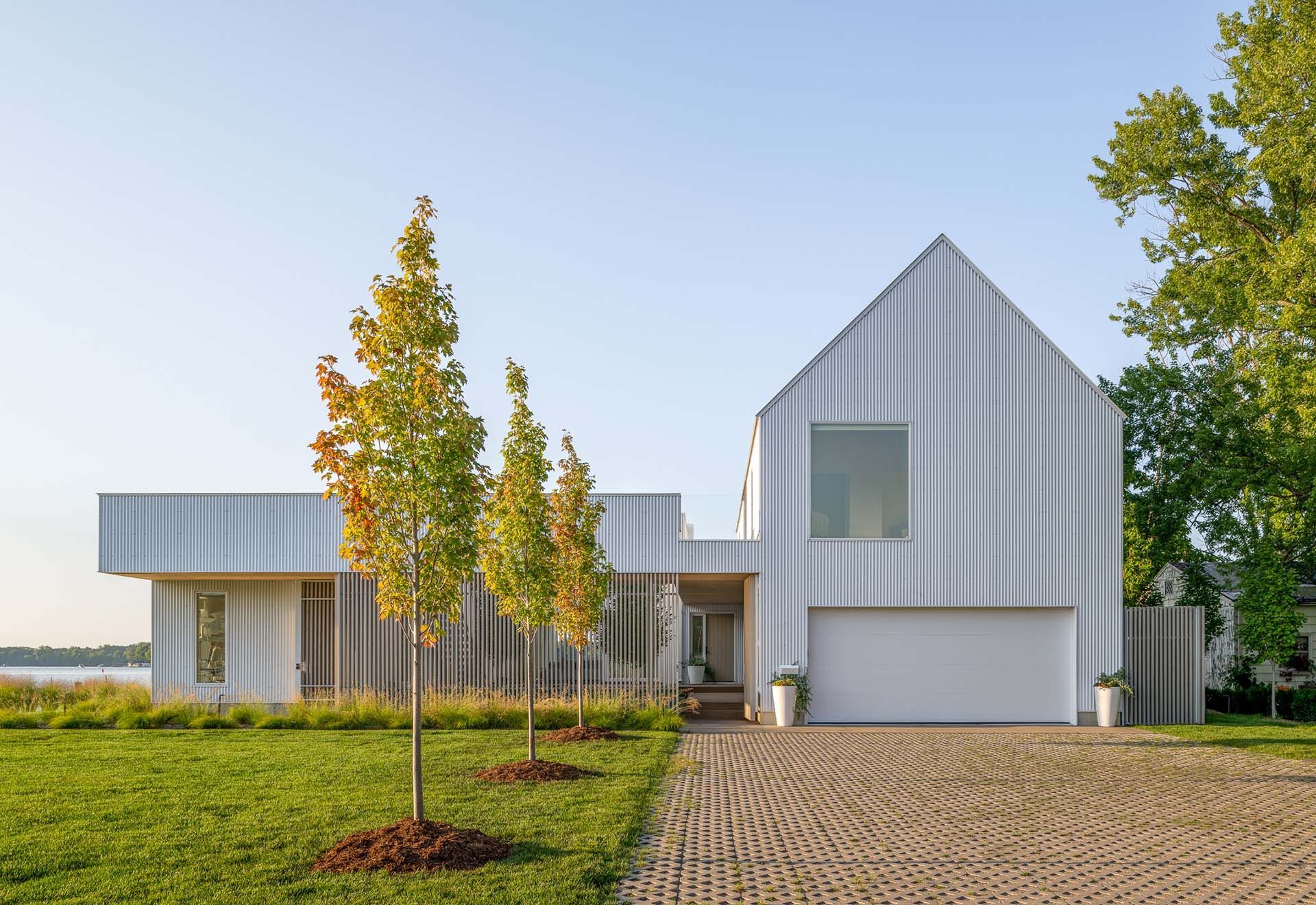 A white house with a garage and a driveway in front of it.