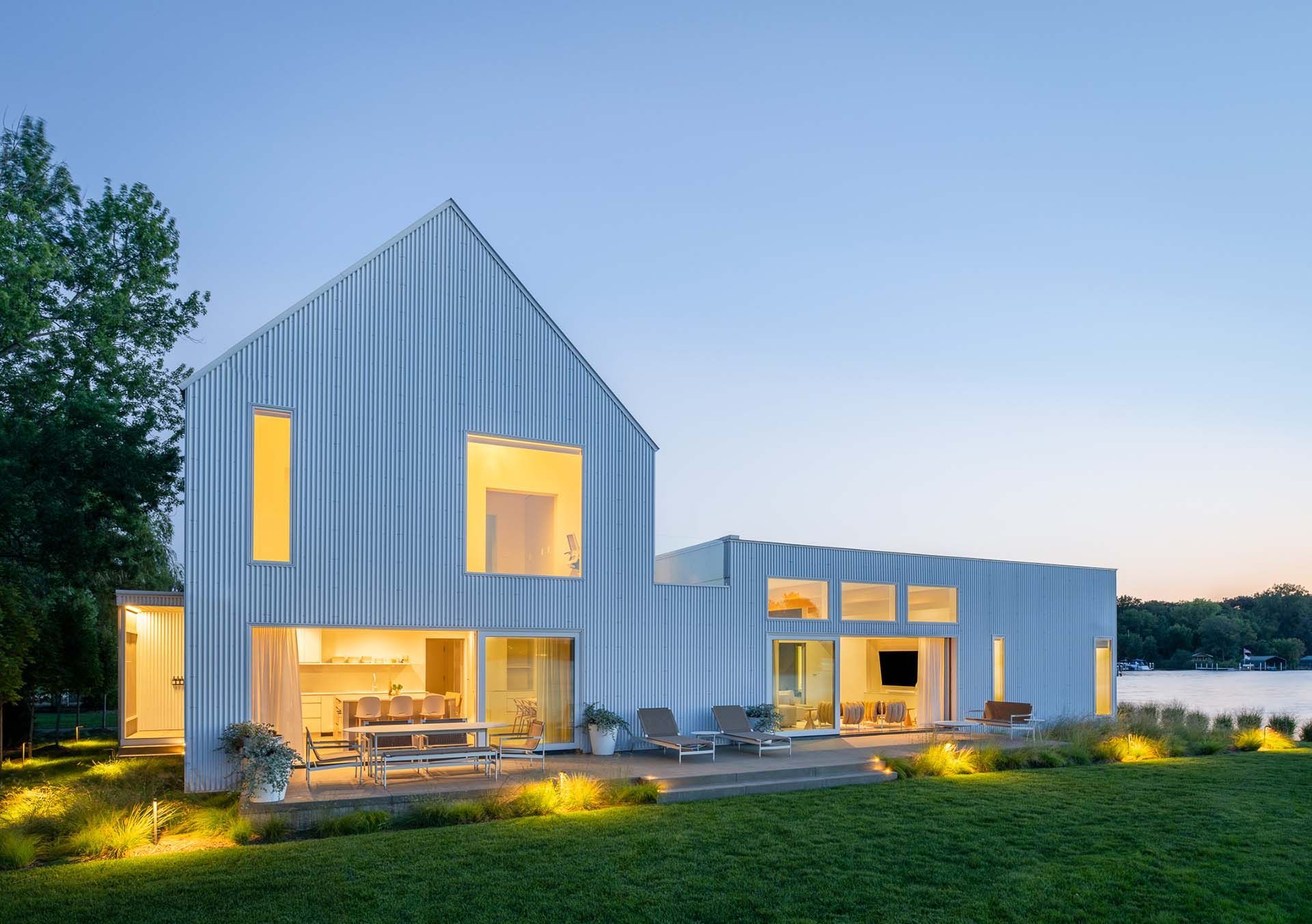 Outside of a custom home in the early evening with the lights on