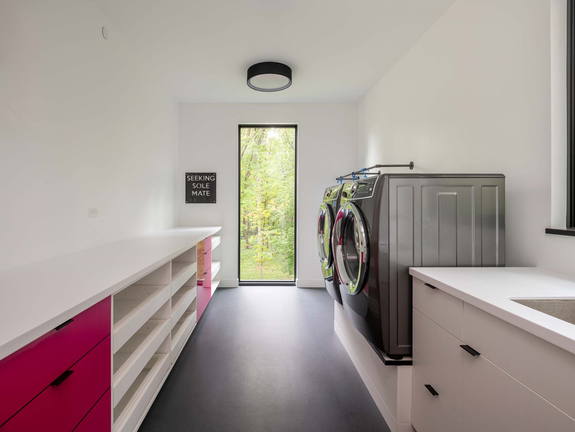 A laundry room with a washer and dryer and a sink.