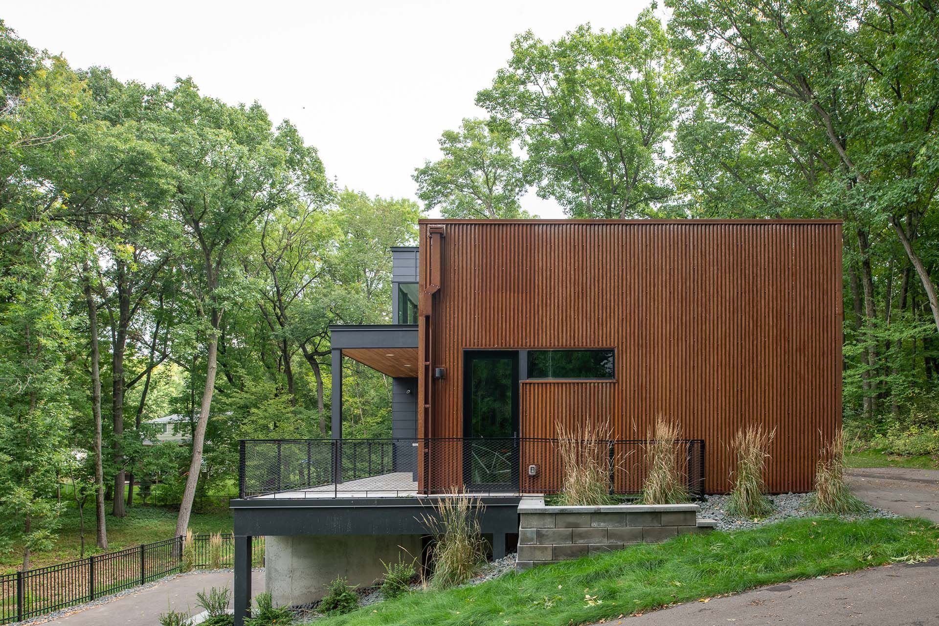 A small wooden house is sitting on top of a hill in the middle of a forest.