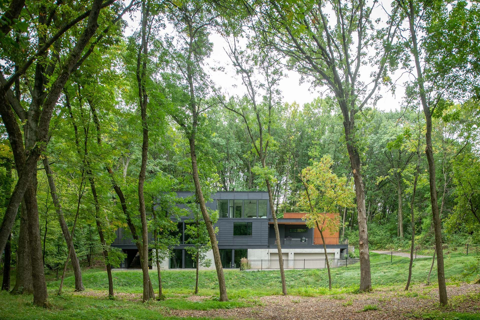 A house is surrounded by trees in the middle of a forest.