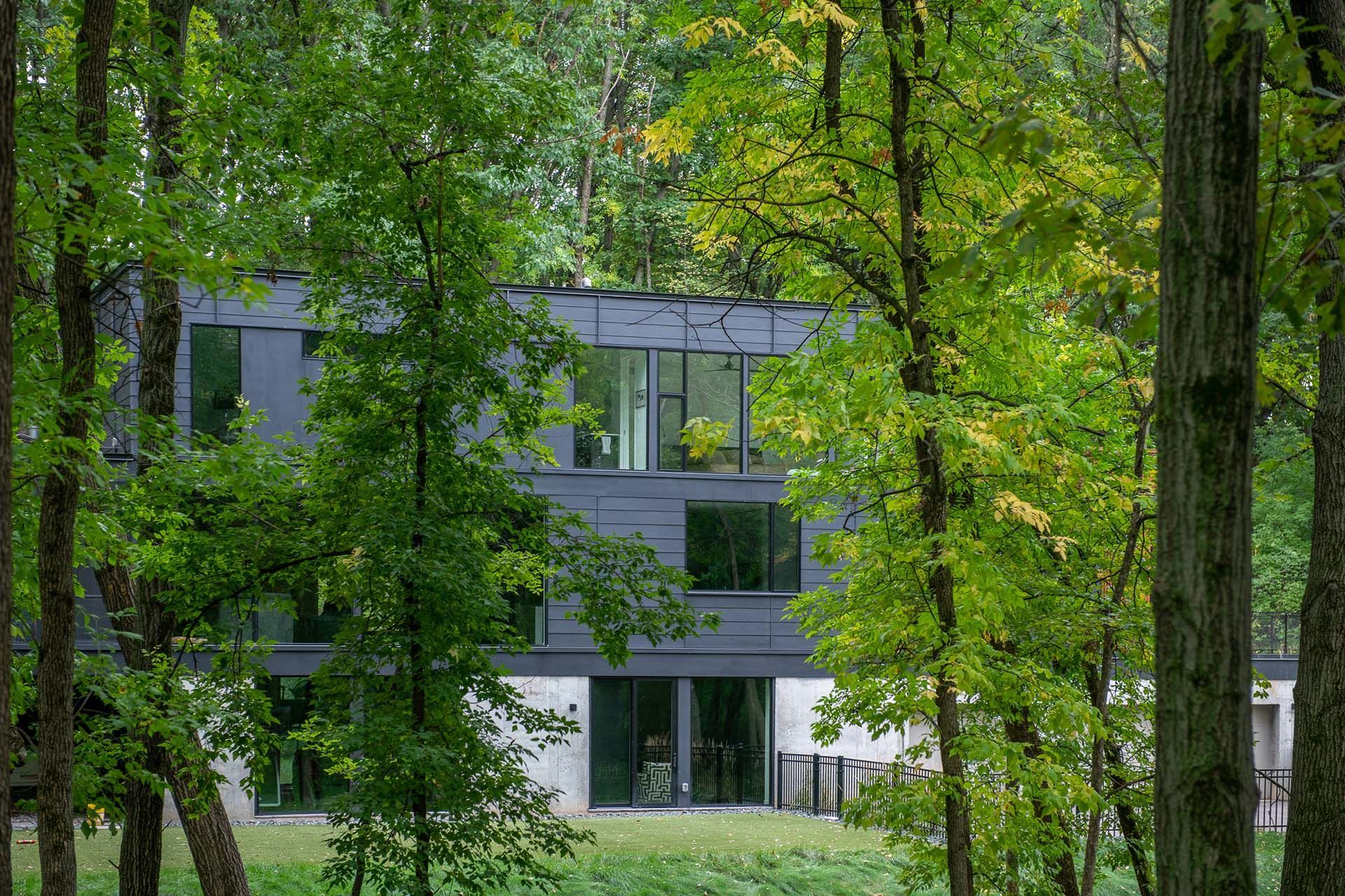A house is surrounded by trees in the middle of a forest.