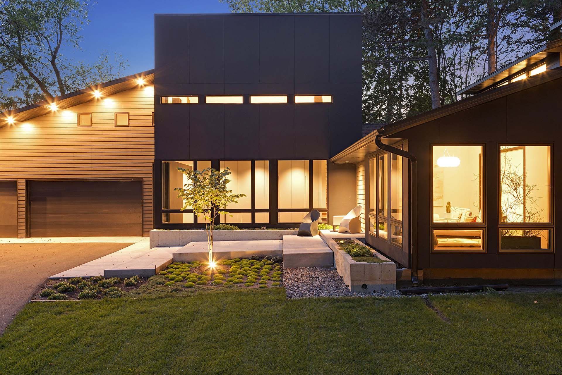 A house with a lot of windows is lit up at night