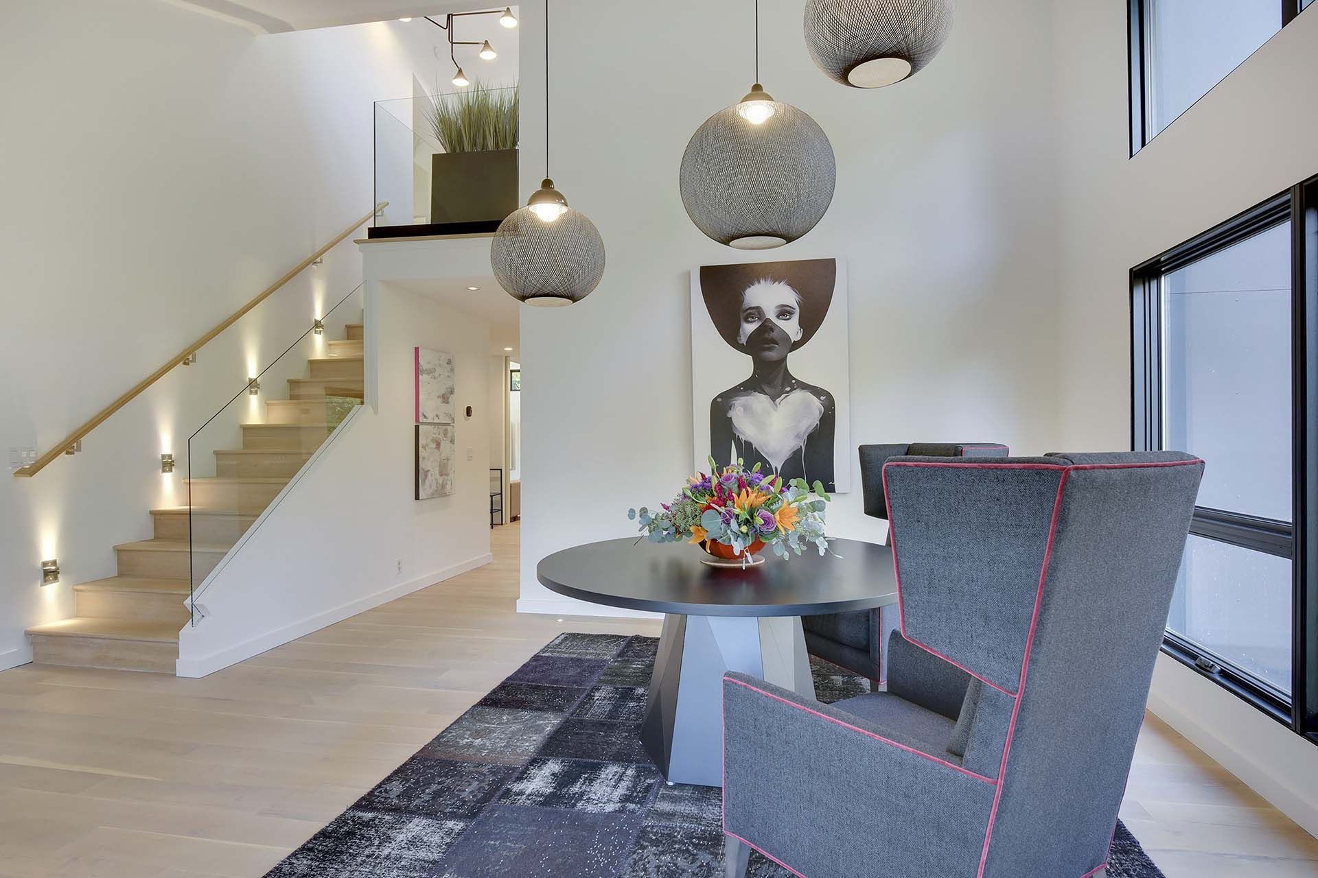 A dining room with a table and chairs and a staircase.