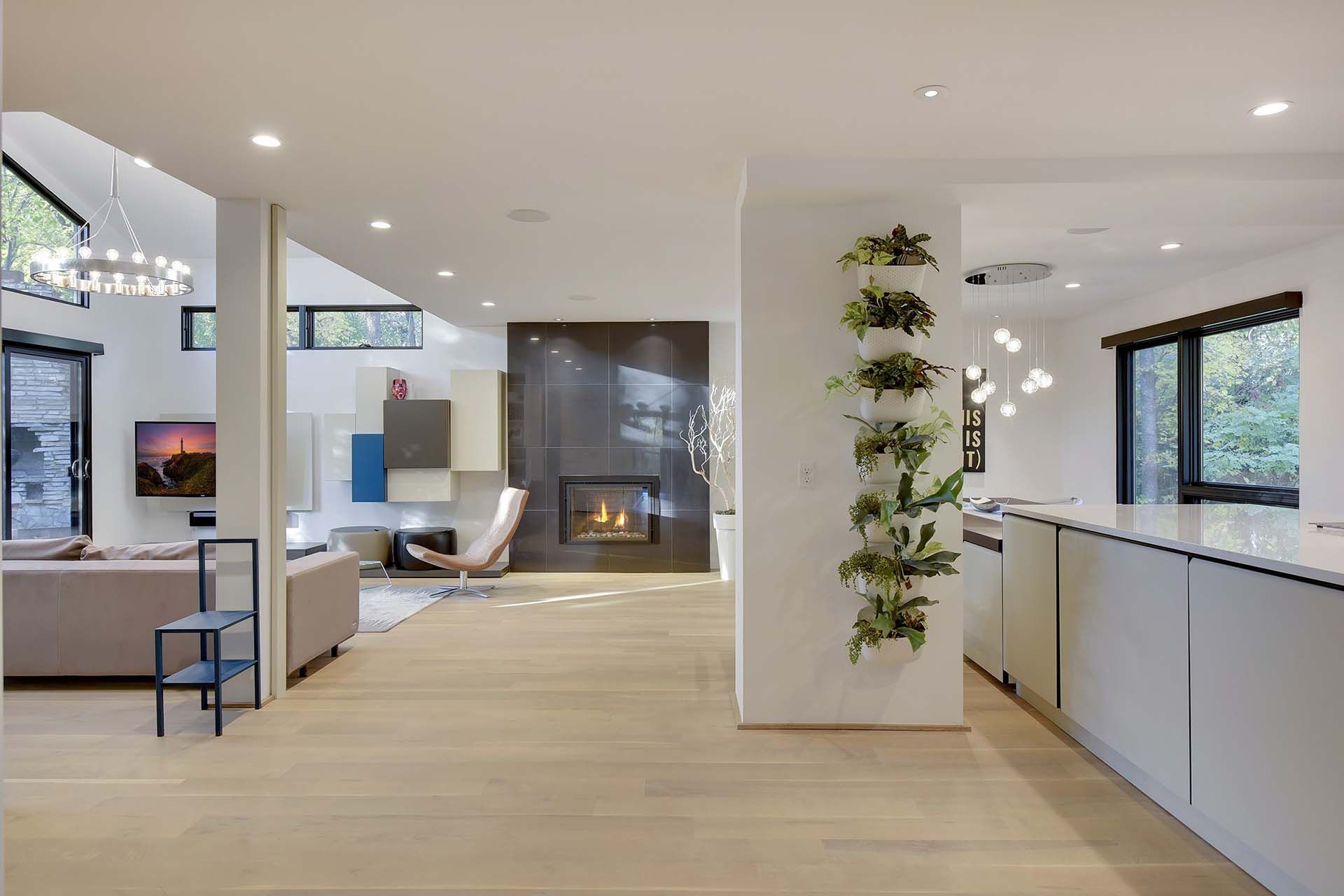 A living room with a fireplace and a kitchen in a modern house.