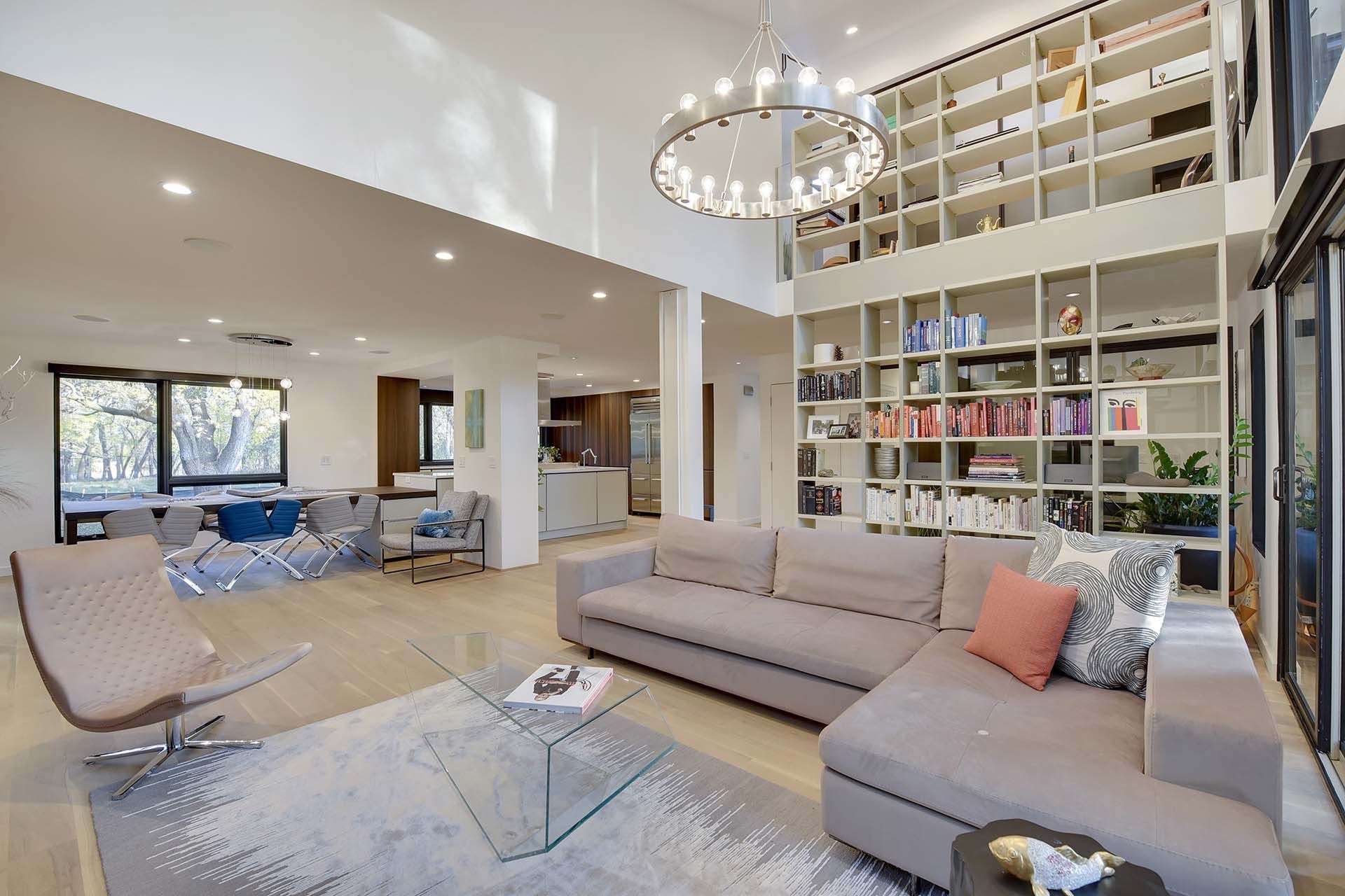 A living room with a couch , chair , coffee table and bookshelf.