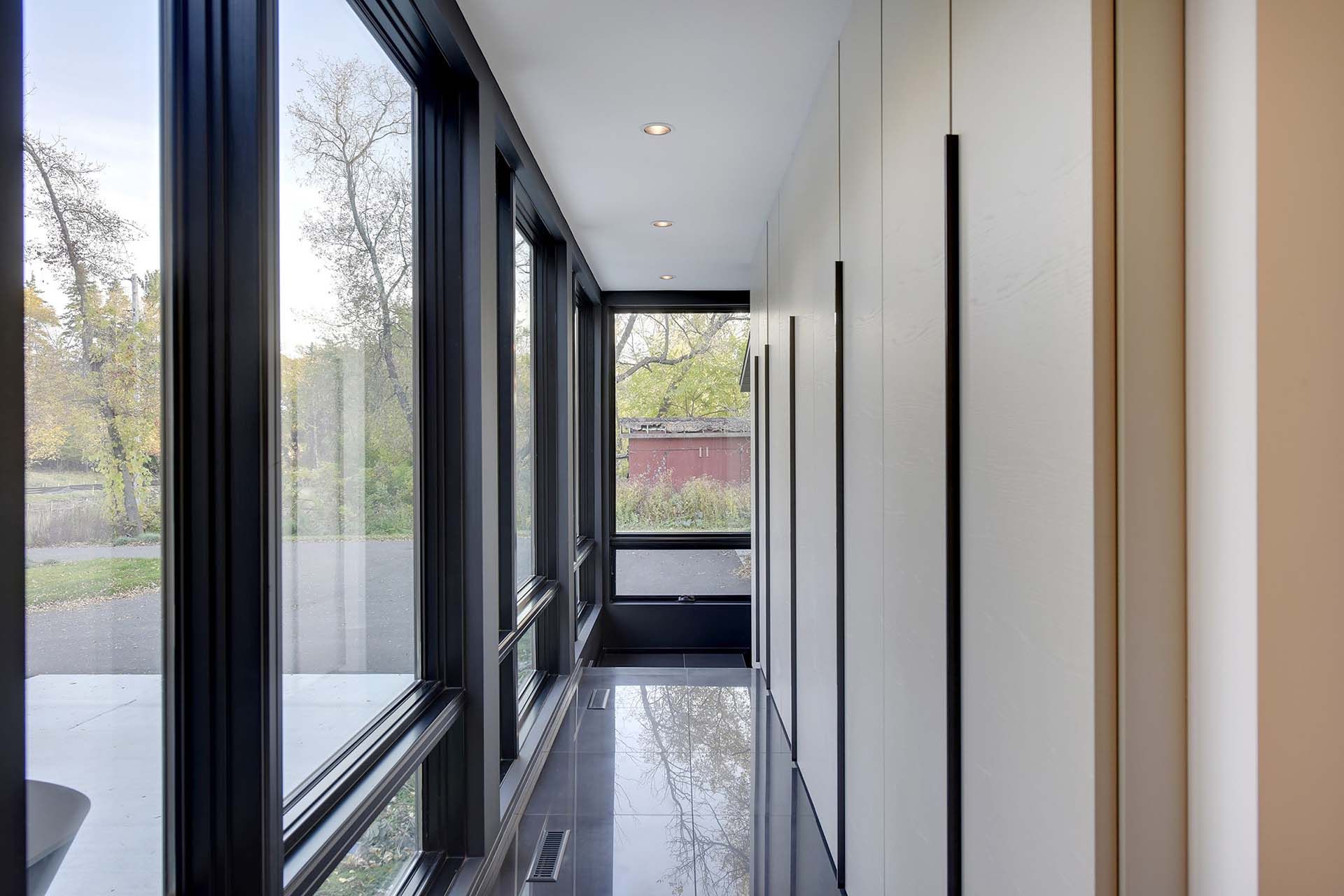 A long hallway with a lot of windows and a marble floor.
