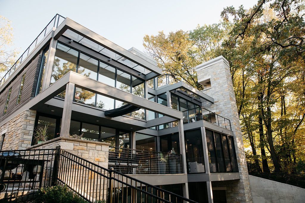 A large house with a lot of windows is surrounded by trees.