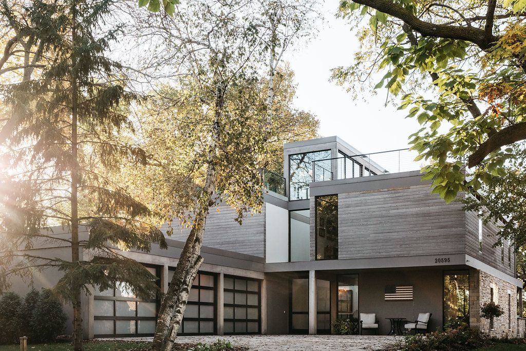 A large house with a lot of windows is surrounded by trees